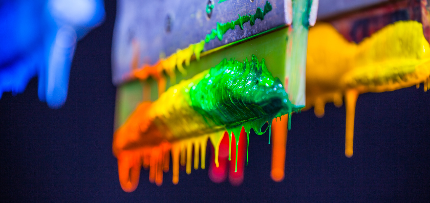Vivid blue, green, orange, and yellow ink on studio brushes